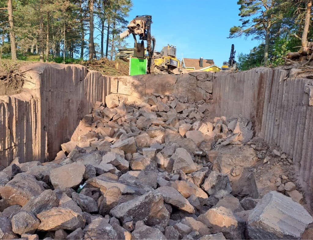 Effektiv slisseboring og sprengning i Bloksbergveien, Husøy i 2023 for veiutbygging til boligtomt. Prosjekt ferdigstilt med suksess.